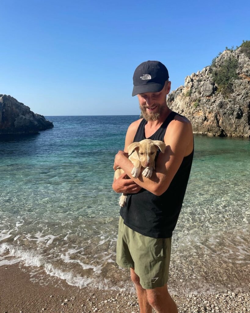 Mann hält Hund am sonnigen Strand
